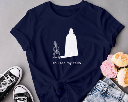 Navy blue t-shirt with a white graphic and text 'You are my cello' on a gray surface with shoes and flowers.